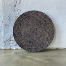 Rund brændt kork med mørk, rustik overflade. Tekstureret og ujævn i udseende.