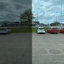 Parkeringsplads delt i to: venstre side tonet og mørkere, højre side klarere med biler og træ synlige.