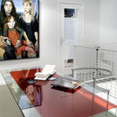 Rød, blank overflade på bord i moderne kontor med notesbog og bærbar computer.