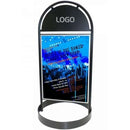 Sort gotisk skilt med logoplade øverst og koncertplakat med blå toner nedenfor.