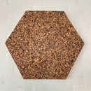 Sekskantet korkdekoration med rustik overflade, monteret på en lys væg.