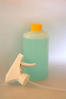 Klar flaske med lyseblå væske, orange låg, hvid spraydyse ved siden af.