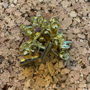 Guldklips med nåle på korkoverflade. Klipsene er beregnet til at fastgøre papirer.