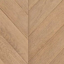 Nærbillede af lysebrun overflade med V-formet chevronmønster i geometrisk stil.