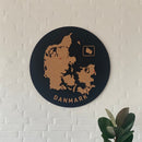 Rund vægpanel med Danmarkskort i kork og teksten "Danmark". Plante ses nedenfor.