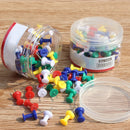 Forskellige farvede nåle i to klare beholdere på en træoverflade. Nåle i rød, blå, gul, grøn, hvid.