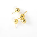 Skinnende guldfarvede nåle med kugleformede hoveder og spidse ender til dekorativ brug.