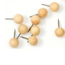 Runde trænåle med kugleformede hoveder og spidse metalspidser, liggende tilfældigt på hvid baggrund.