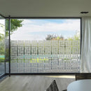 Stort glasvindue med geometrisk mønsterfilm for lysindfald og delvis udsyn.