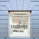 Storefront med figurskåret folie, logo og tekst "LISEBORG creative company" på vindue.