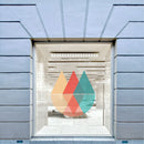Butiksvindue med klar folie, geometrisk design i orange, rød og teal. Lys passerer gennem mønsteret.